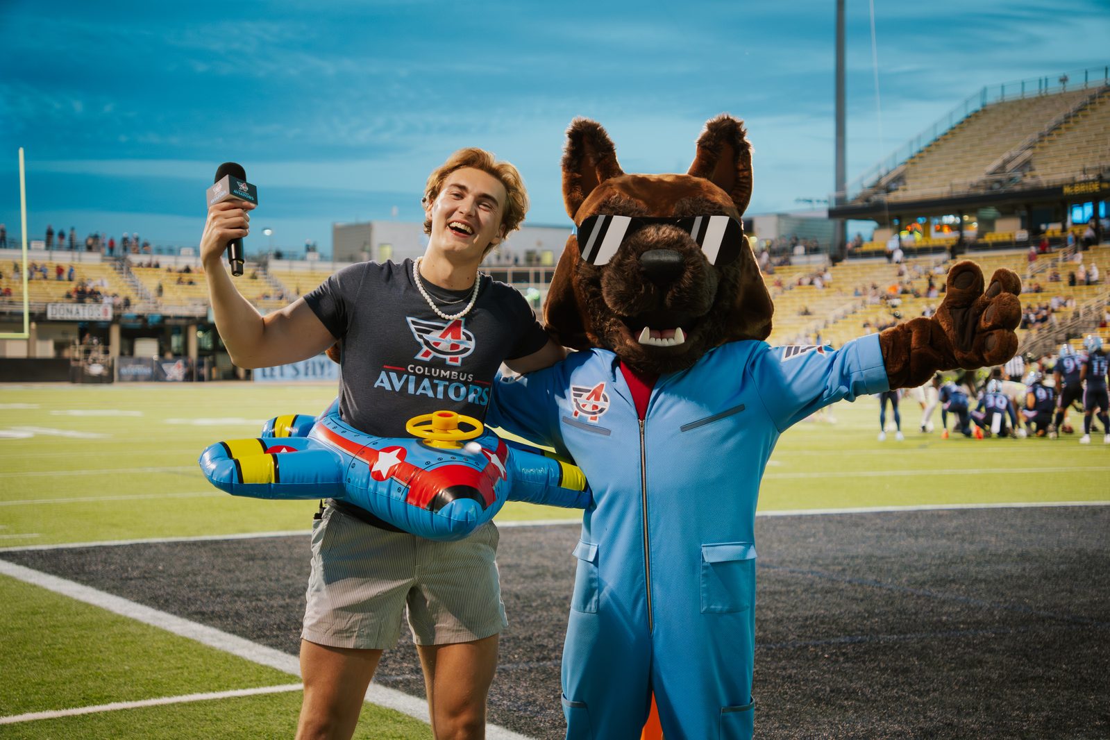 Columbus Aviators mascot with fan holding inflatable plane prop