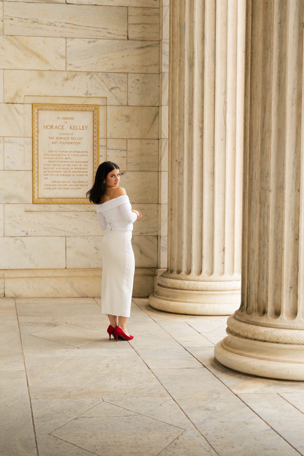 Woman in white outfit posing by columns at the Cleveland Museum of Art