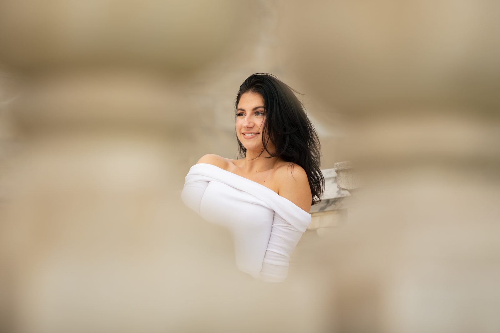 Close-up portrait of a woman smiling with hair blowing in the wind