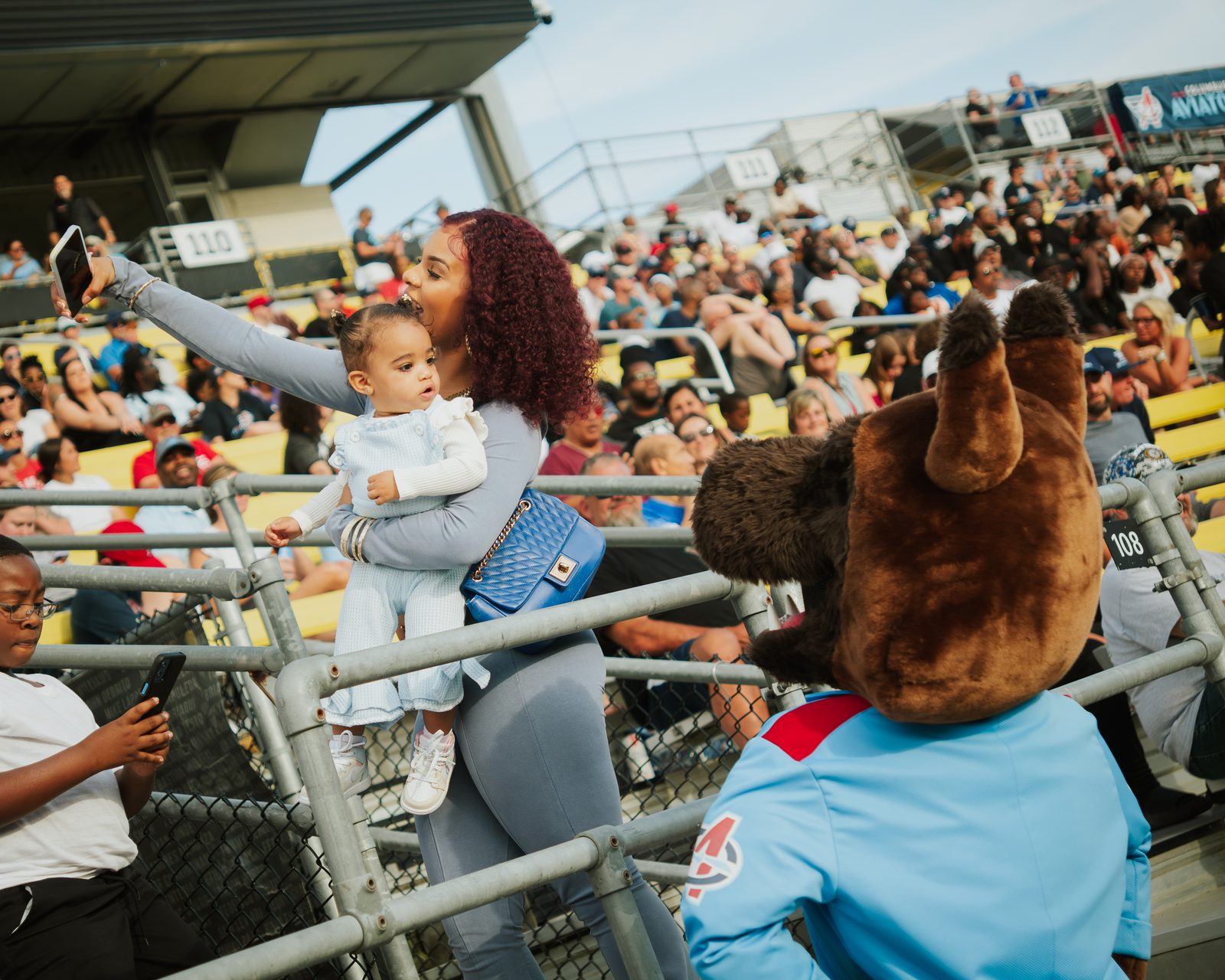 Mother and toddler taking a selfie with the Aviators mascot
